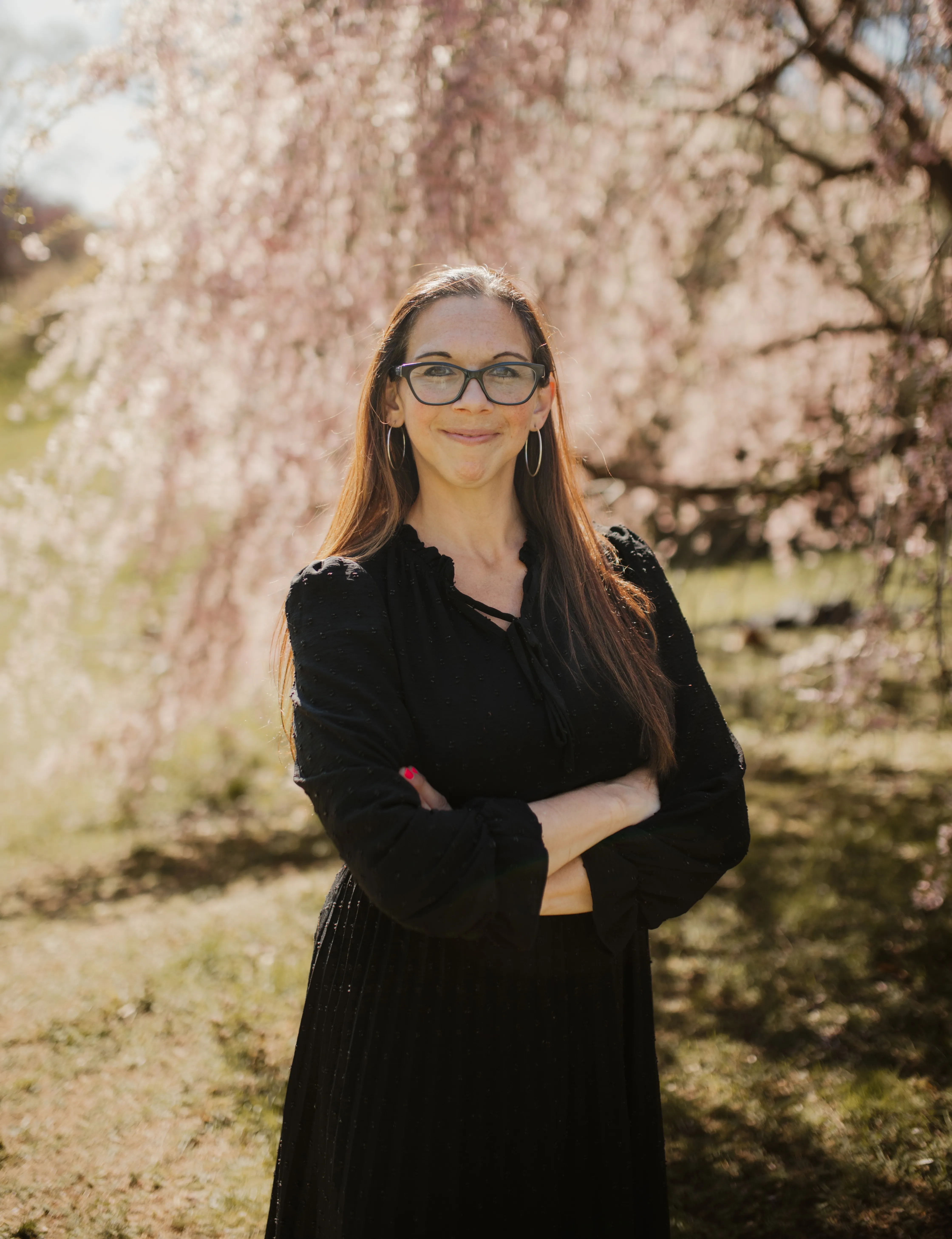 Jessica Morillo, couples and sex therapist, standing among spring blossoms